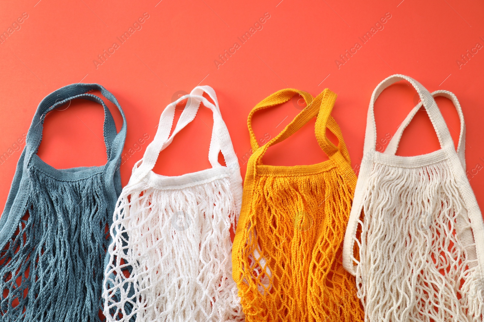 Photo of Different string bags on red background, top view
