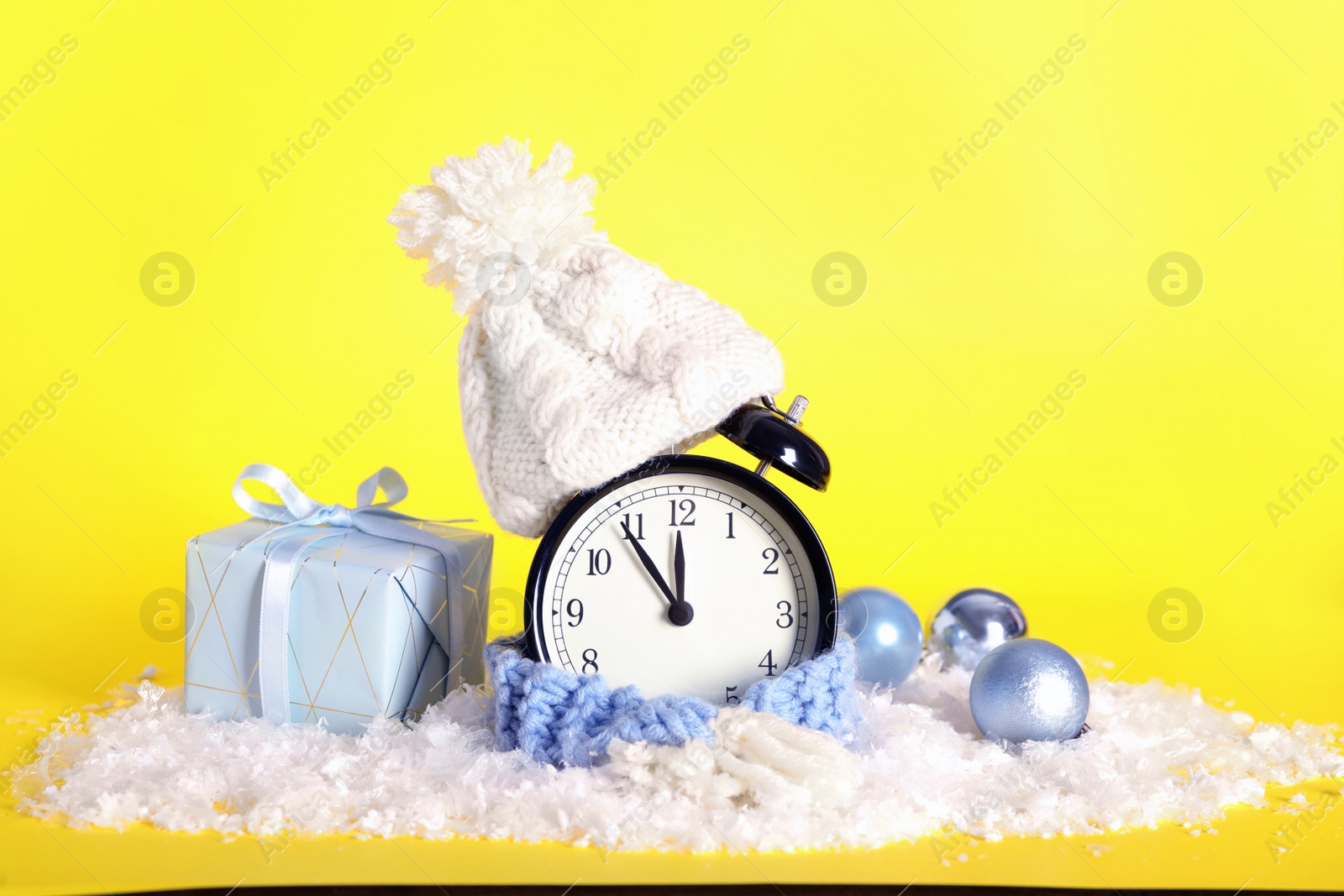 Photo of Vintage alarm clock with Christmas decor on yellow background. New Year countdown