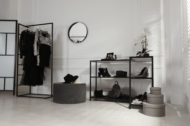 Stylish dressing room interior with trendy clothes, shoes and accessories