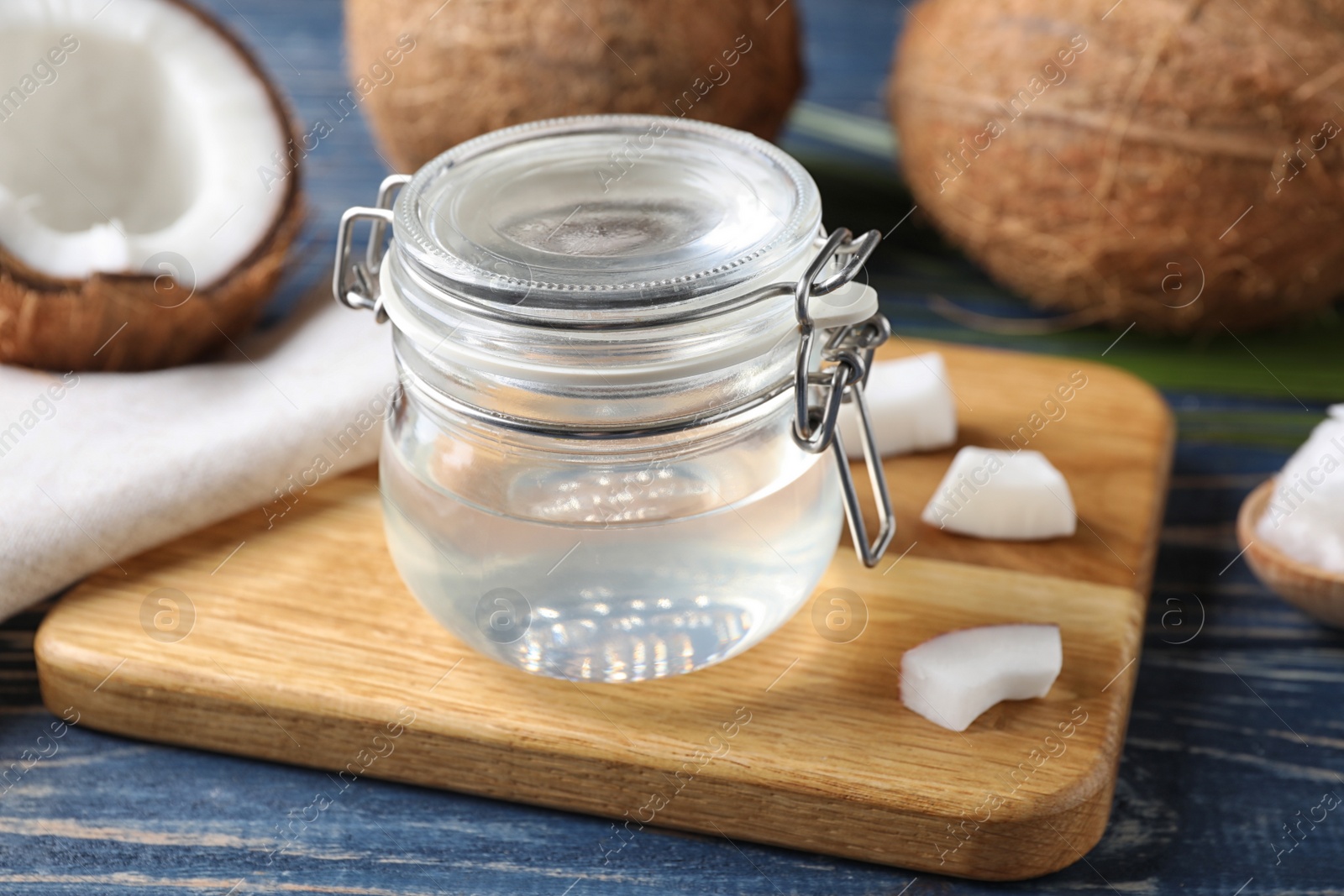 Photo of Coconut oil on blue wooden table, closeup view