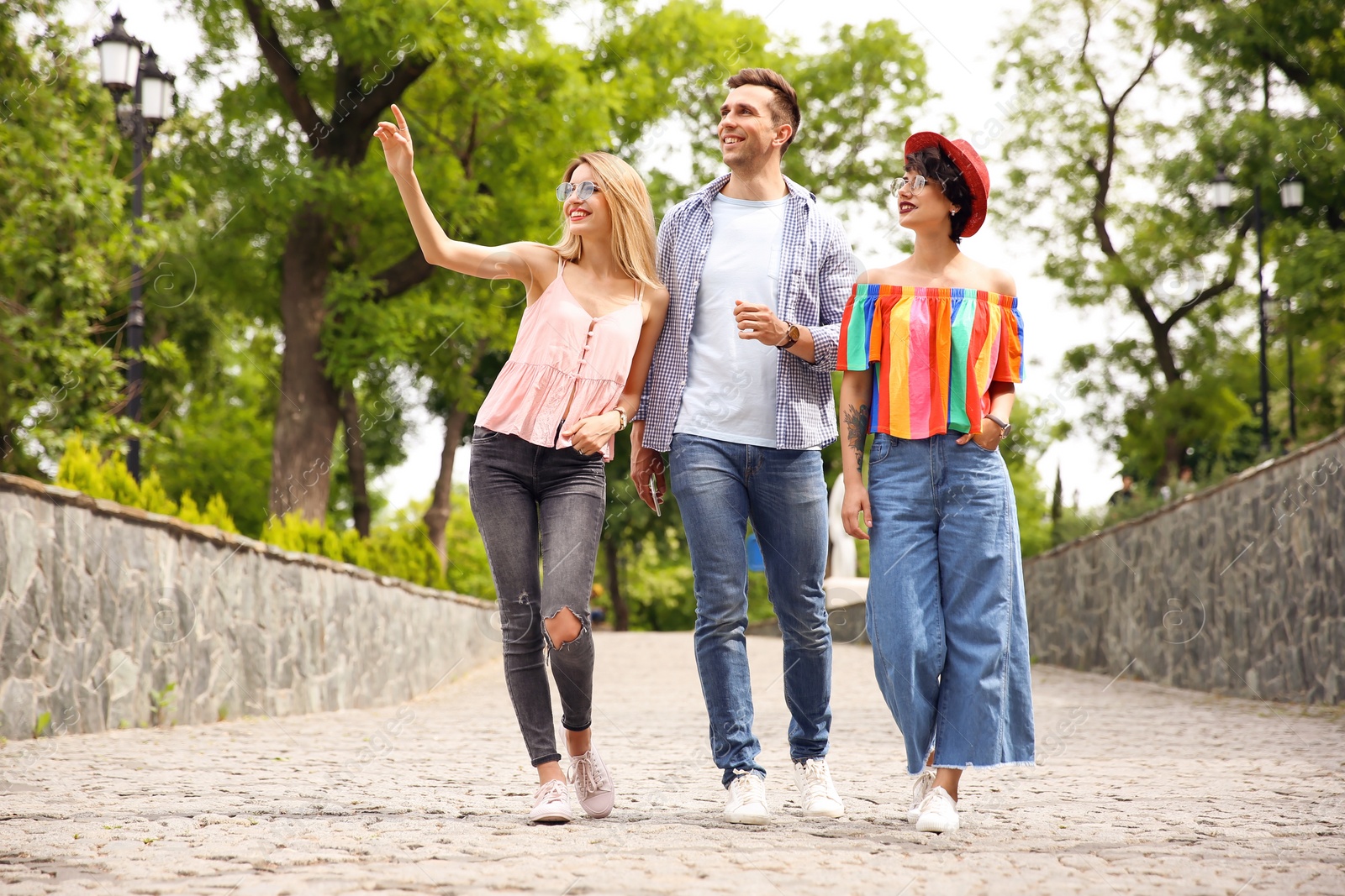 Photo of Group of friends in stylish clothes spending time together outdoors