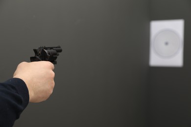Photo of Man aiming at shooting target indoors, closeup. Space for text
