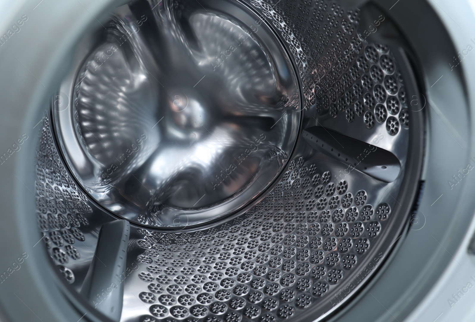 Photo of Empty washing machine drum, closeup. Laundry day