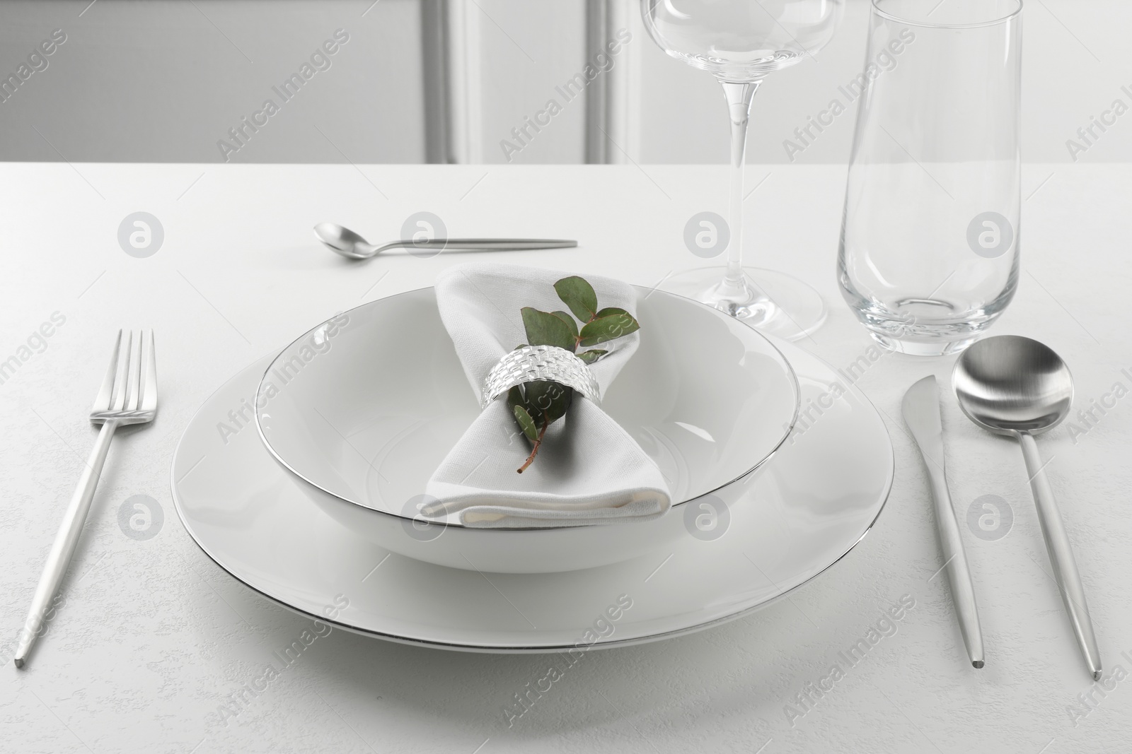 Photo of Stylish setting with cutlery and napkin on white textured table