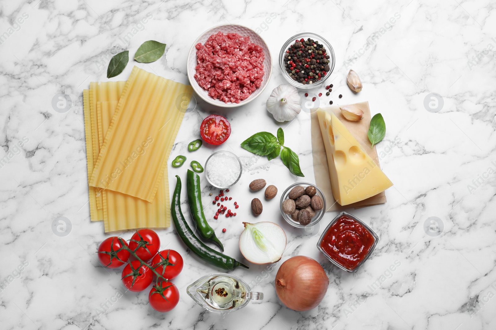 Photo of Fresh ingredients for lasagna on white marble table, flat lay