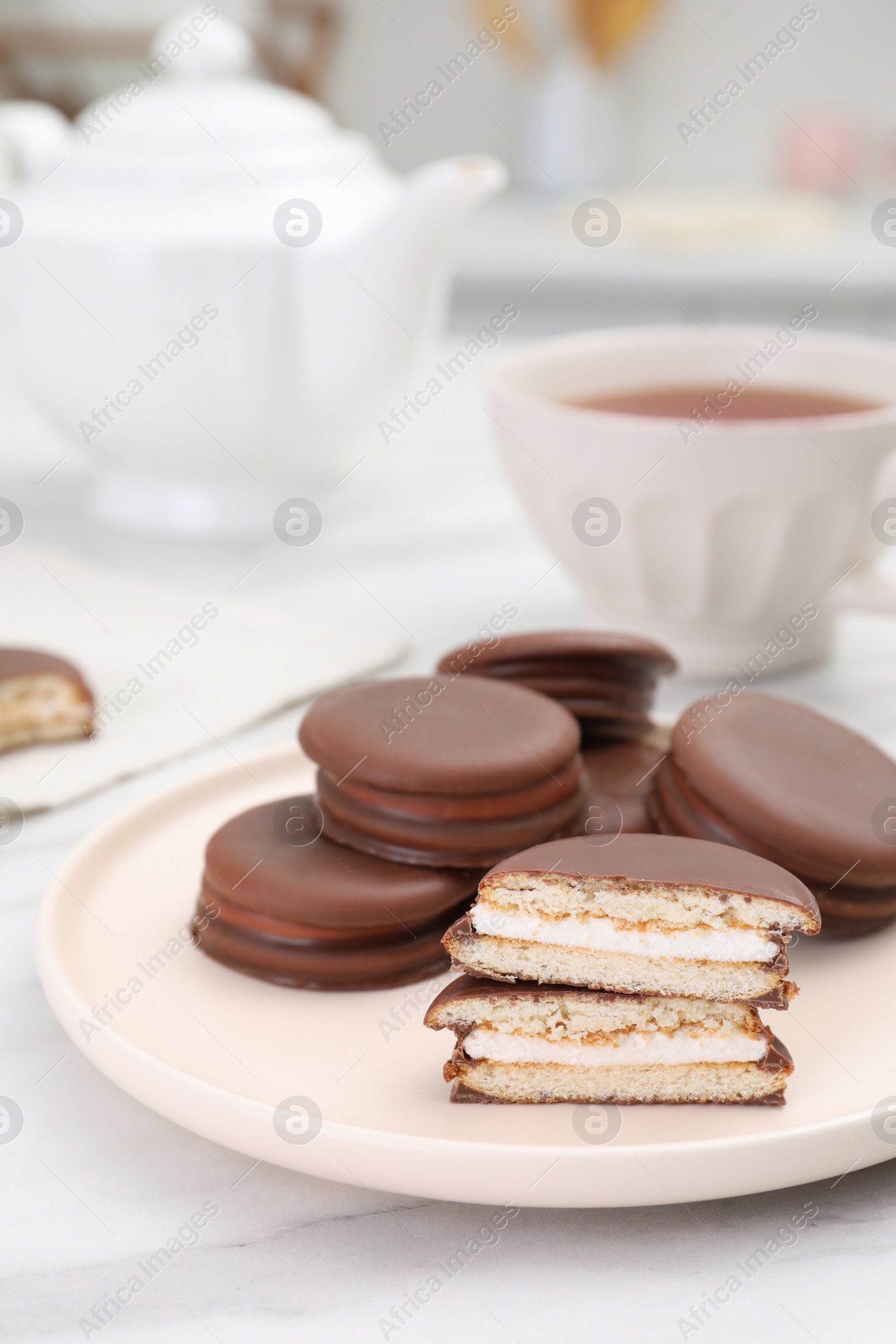 Photo of Plate with delicious choco pies on white marble table in kitchen