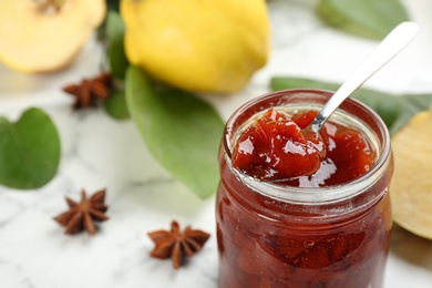 Photo of Delicious quince jam on light table, closeup