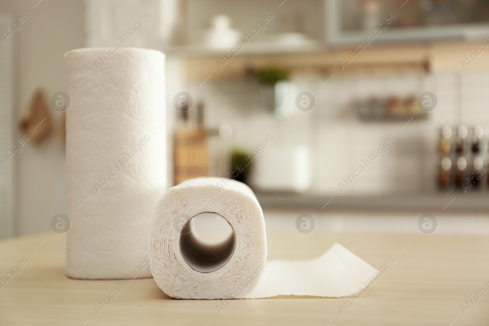 Photo of Rolls of paper towels on table in kitchen. Space for text