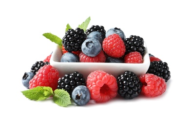 Photo of Bowl with raspberries, blackberries and blueberries on white background