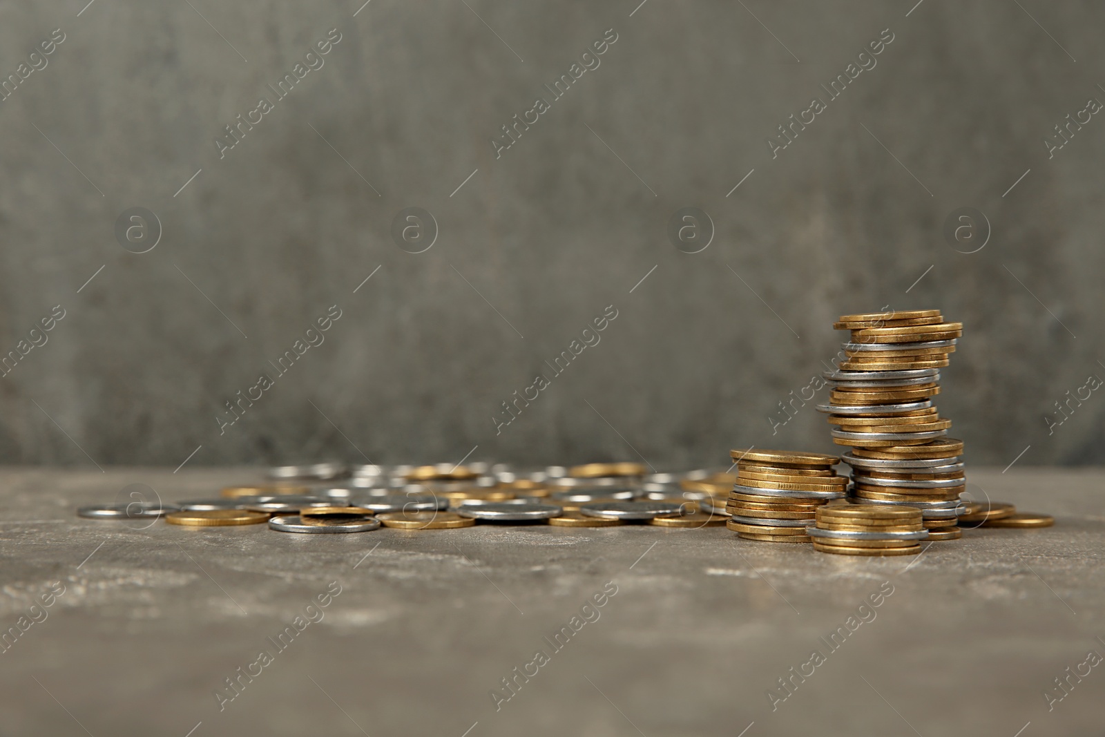 Photo of Many coins on table against color background, space for text