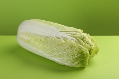 Photo of Fresh ripe Chinese cabbage on light green background, closeup