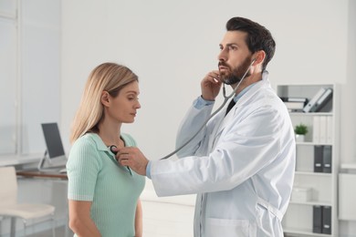 Photo of Doctor examining patient with stethoscope in clinic