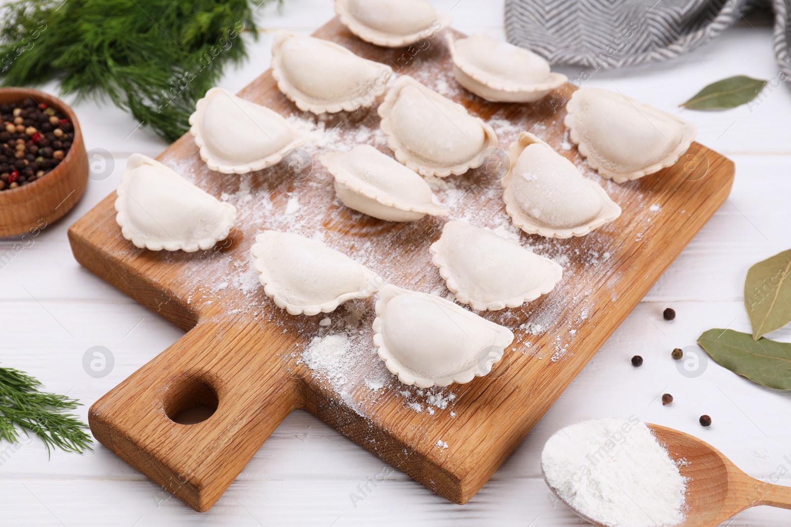 Photo of Raw dumplings (varenyky) on white wooden table, closeup