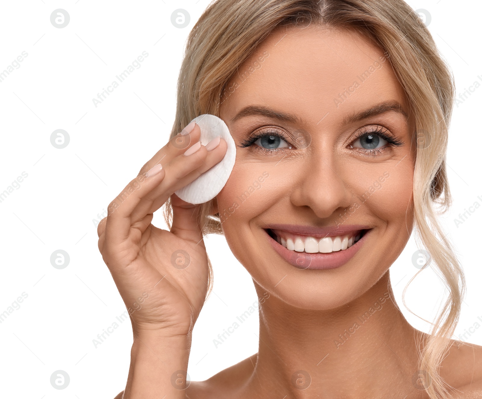 Photo of Smiling woman removing makeup with cotton pad on white background