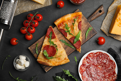 Photo of Flat lay composition with tasty pepperoni pizza on black table