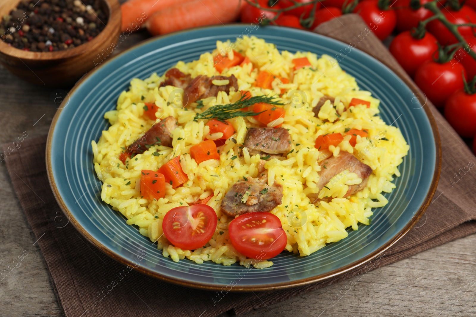 Photo of Delicious pilaf with meat and vegetables on wooden table, closeup