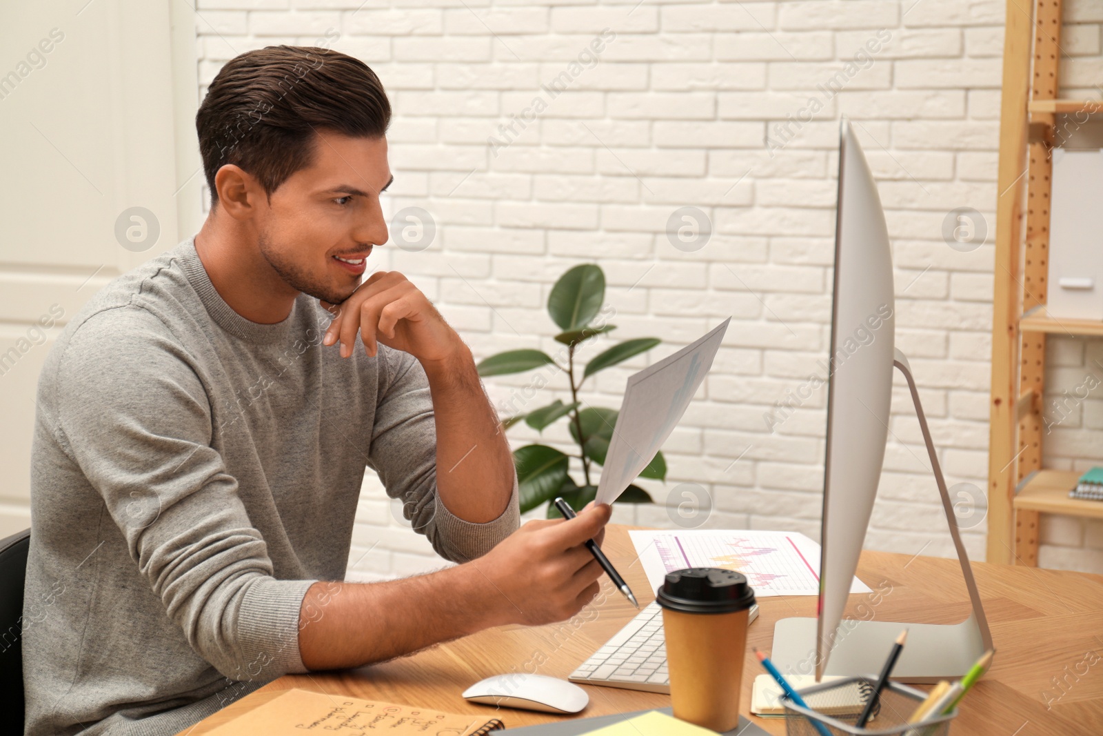 Photo of Man working with document at table in office