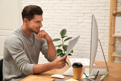 Man working with document at table in office