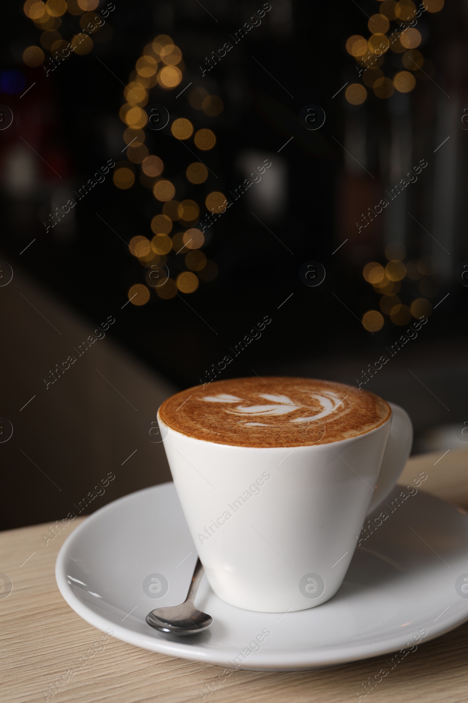 Photo of Cup of aromatic coffee on wooden table in cafe, space for text