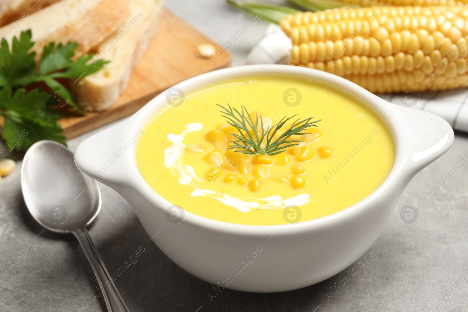 Photo of Delicious creamy corn soup served on grey table