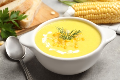 Delicious creamy corn soup served on grey table