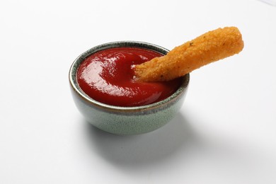 Photo of Delicious cheese stick and ketchup in bowl on white table