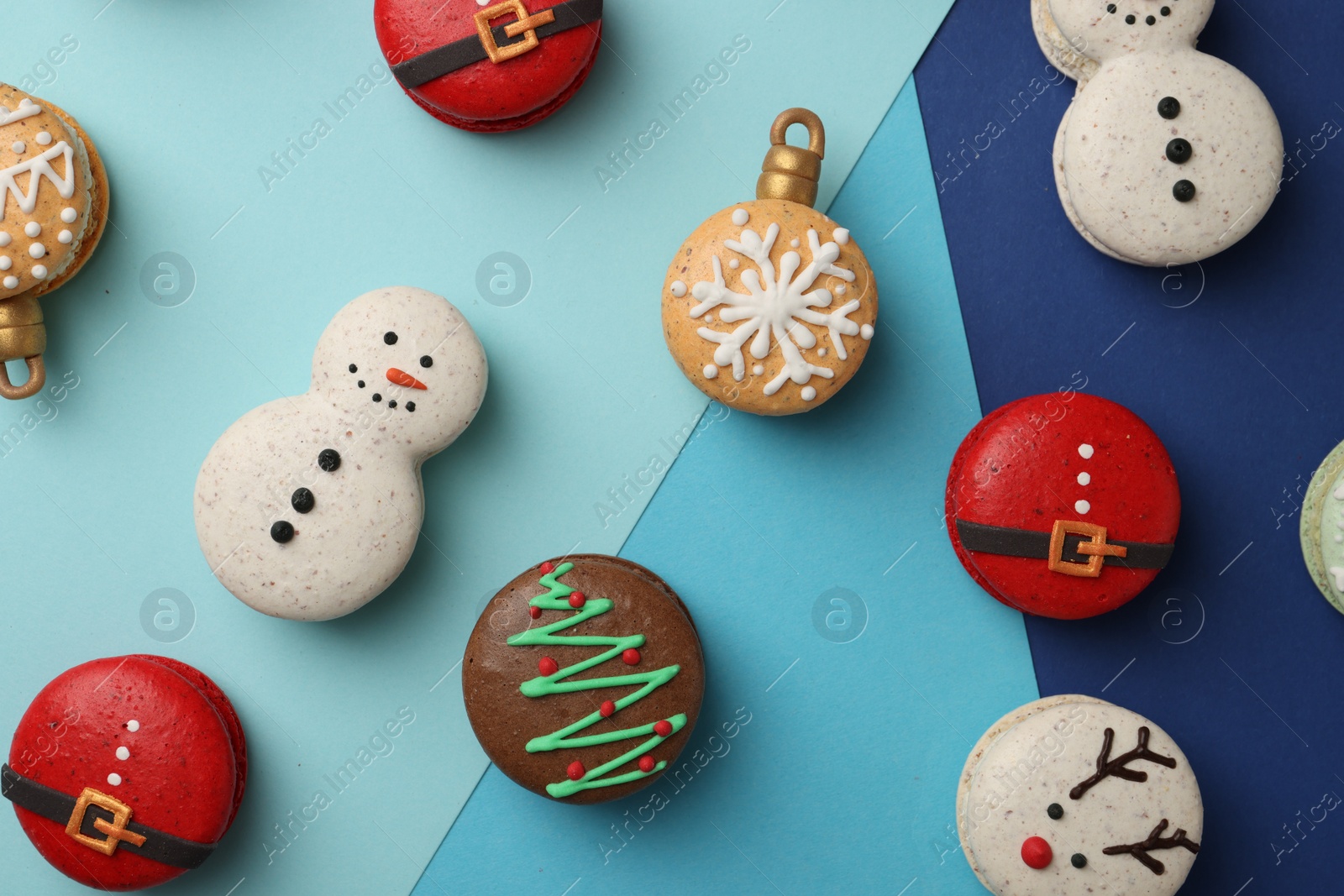 Photo of Beautifully decorated Christmas macarons on color background, flat lay