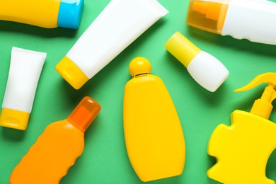 Photo of Suntan products on green background, flat lay