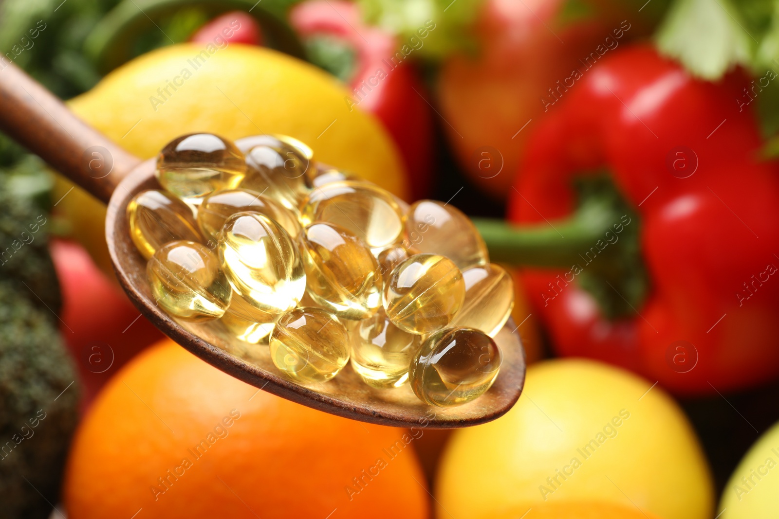 Photo of Dietary supplements. Spoon with capsules over food products, closeup. Space for text