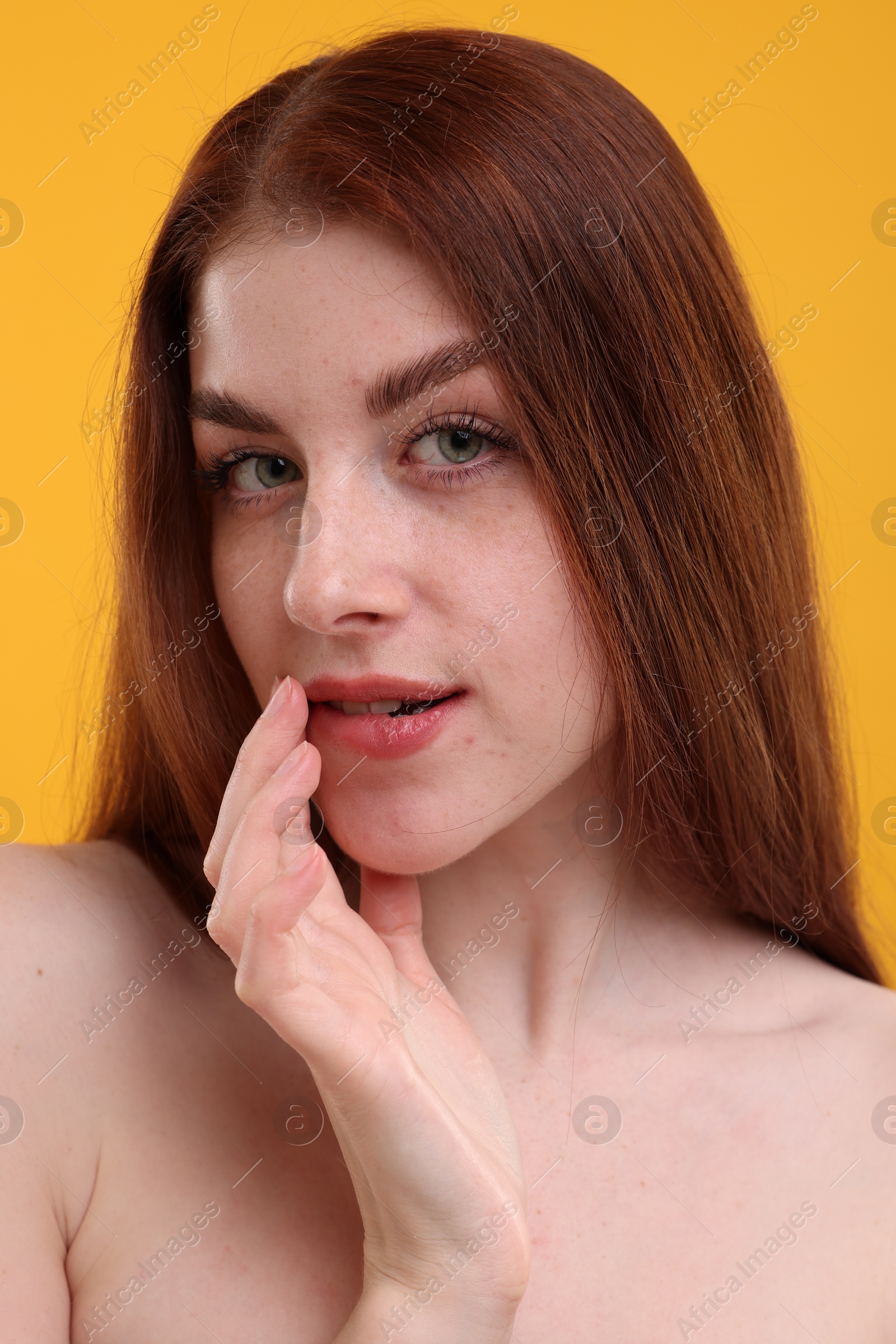 Photo of Portrait of beautiful woman with freckles on yellow background