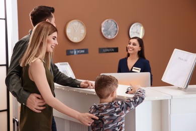 Photo of Young family near reception desk in hotel