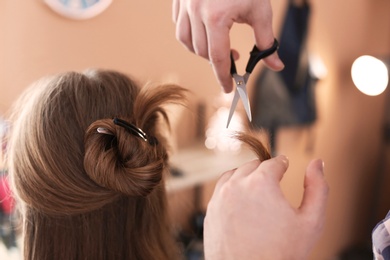 Photo of Professional hairdresser working with client in beauty salon, closeup