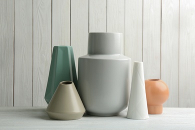 Photo of Stylish ceramic vases on white wooden table