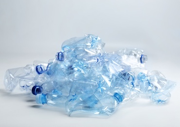 Photo of Heap of used plastic bottles on white background. Recycling problem