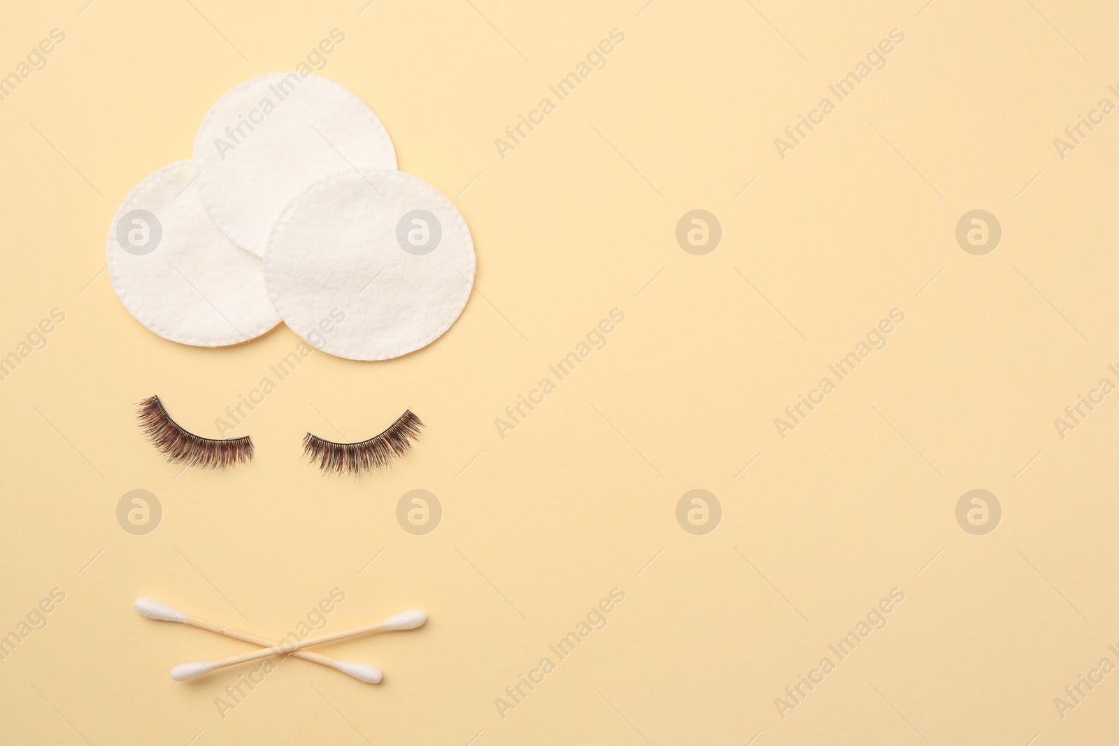 Photo of Flat lay composition with makeup removal tools and false eyelashes on yellow background. Space for text