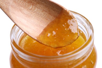 Image of Spoon with apricot jam in jar on white background, closeup
