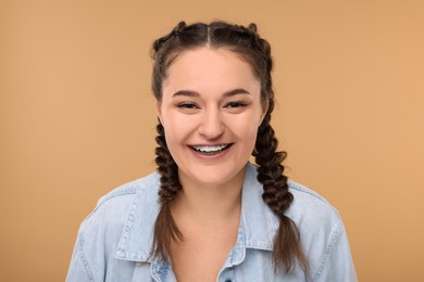 Photo of Laughing woman with braces on beige background