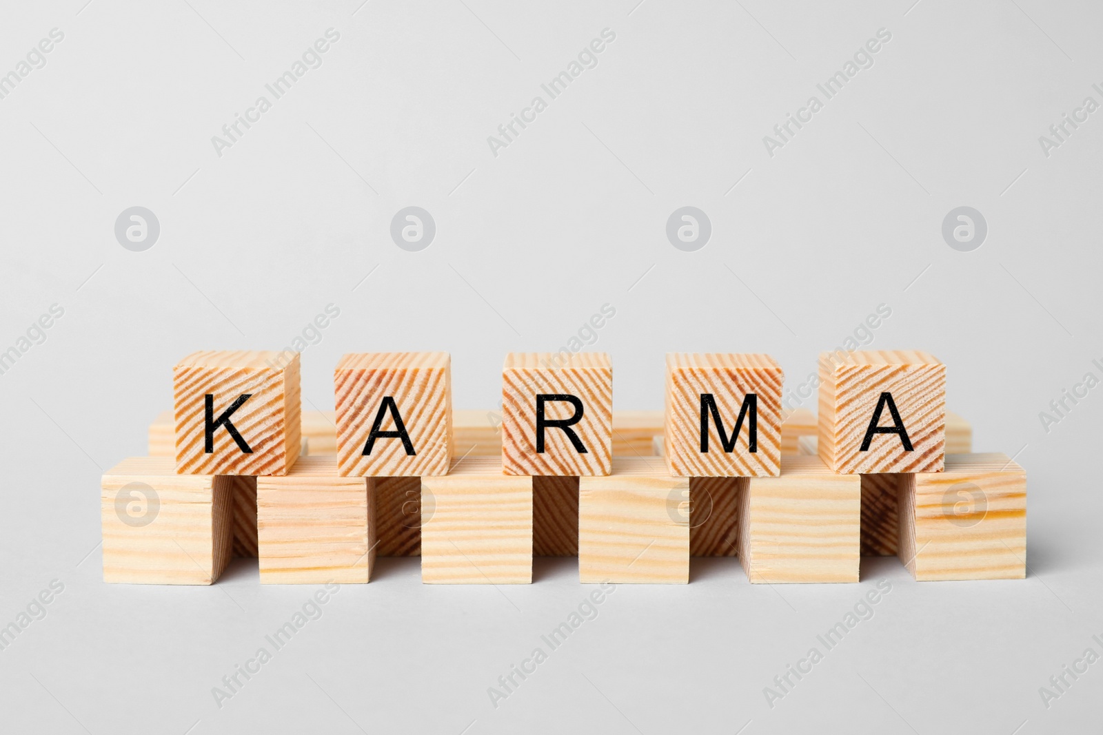 Photo of Word Karma made of cubes with letters on light background