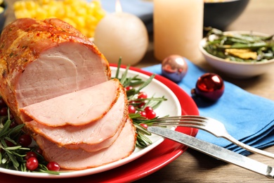 Photo of Delicious Christmas ham served with garnish on wooden table