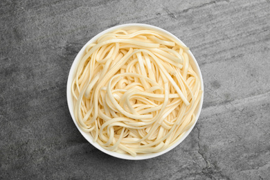 Photo of Tasty rice noodles on grey table, top view