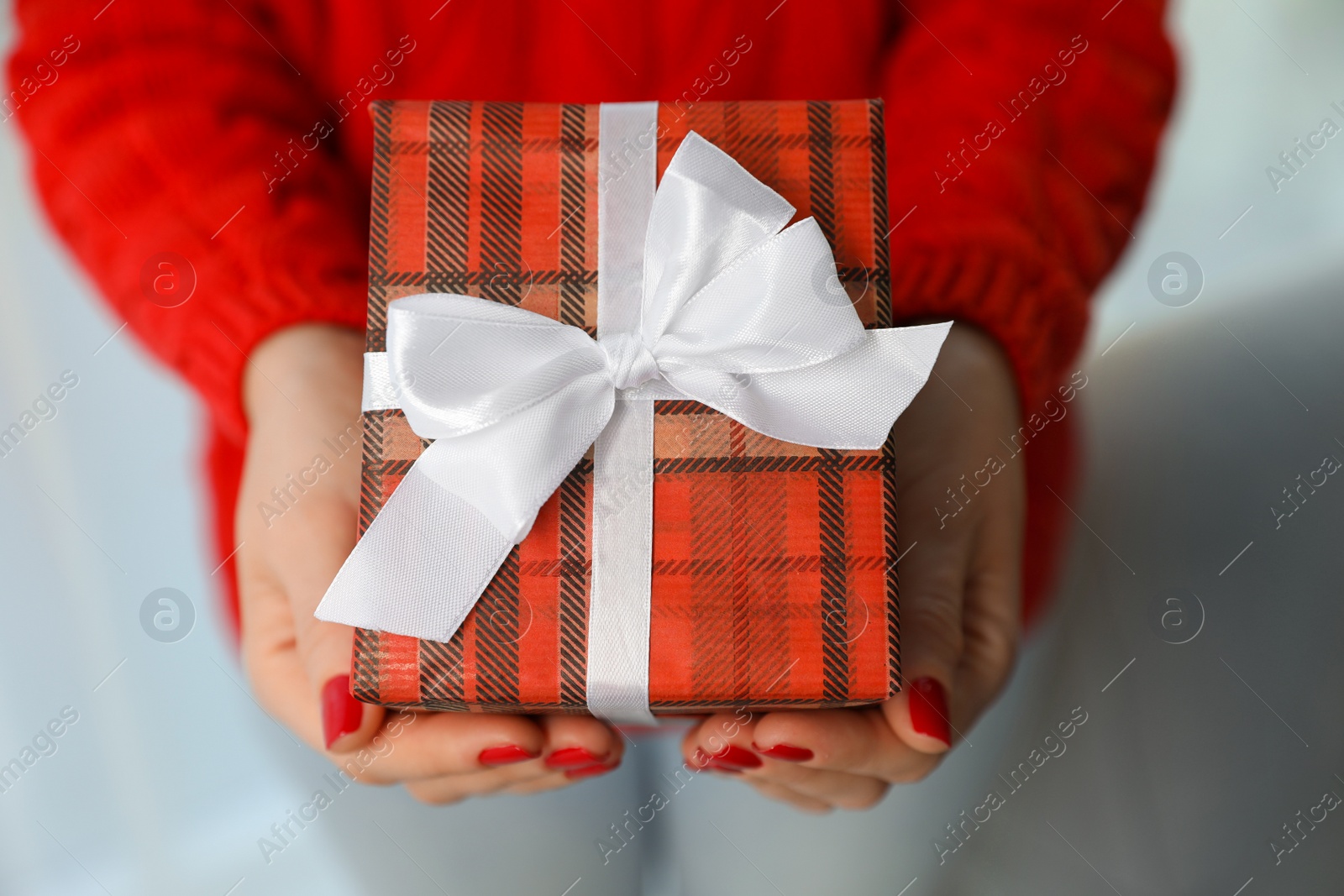 Photo of Woman holding gift box, closeup. Christmas holiday