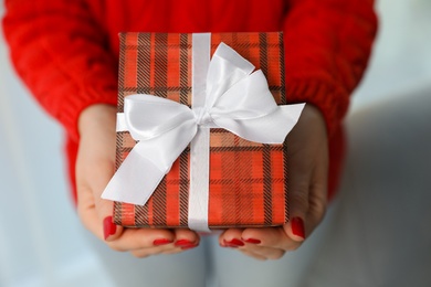 Woman holding gift box, closeup. Christmas holiday