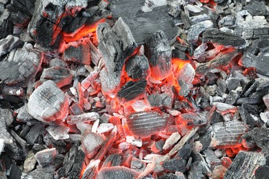 Photo of Many smoldering coals as background, closeup view