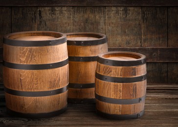 Image of Three wooden barrels of different sizes in cellar
