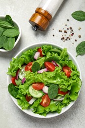 Photo of Delicious salad in bowl on light grey table, flat lay