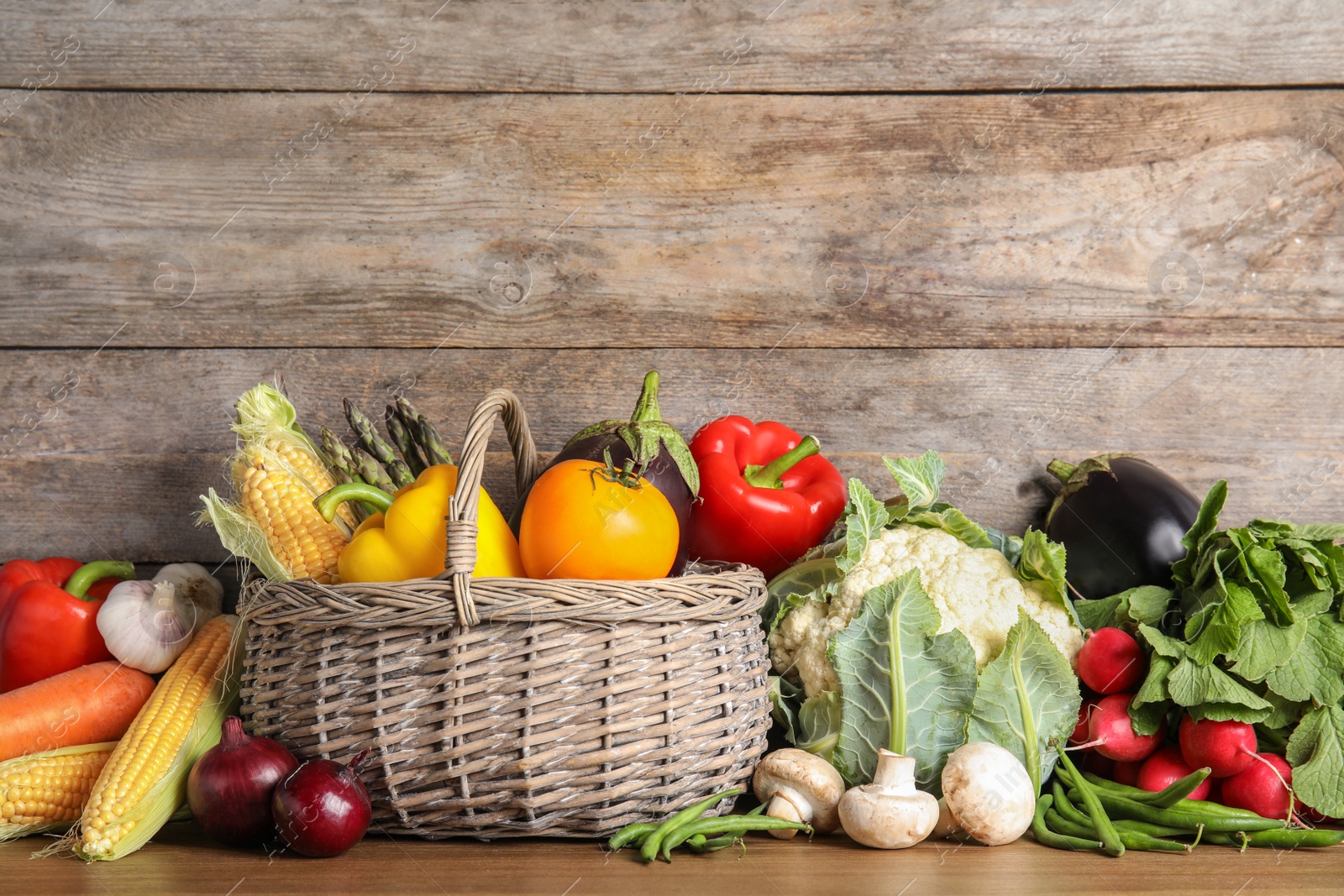 Photo of Assortment of fresh vegetables on table against wooden background. Space for text