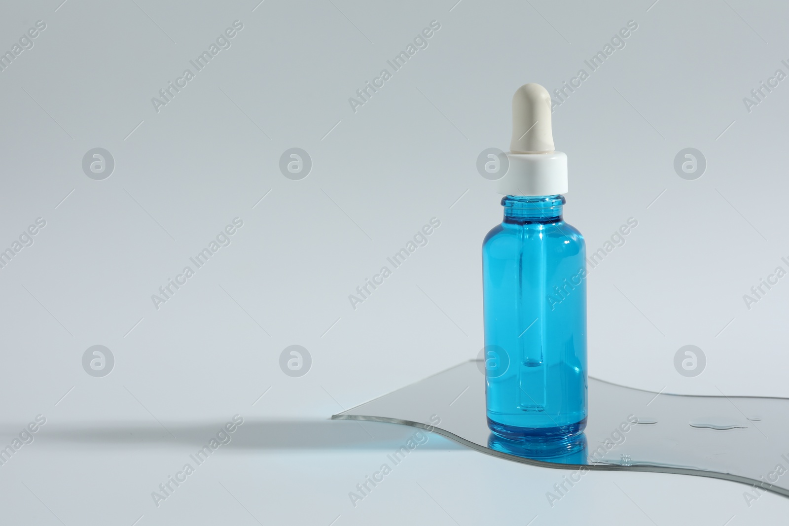 Photo of Bottle with cosmetic product on light background, space for text