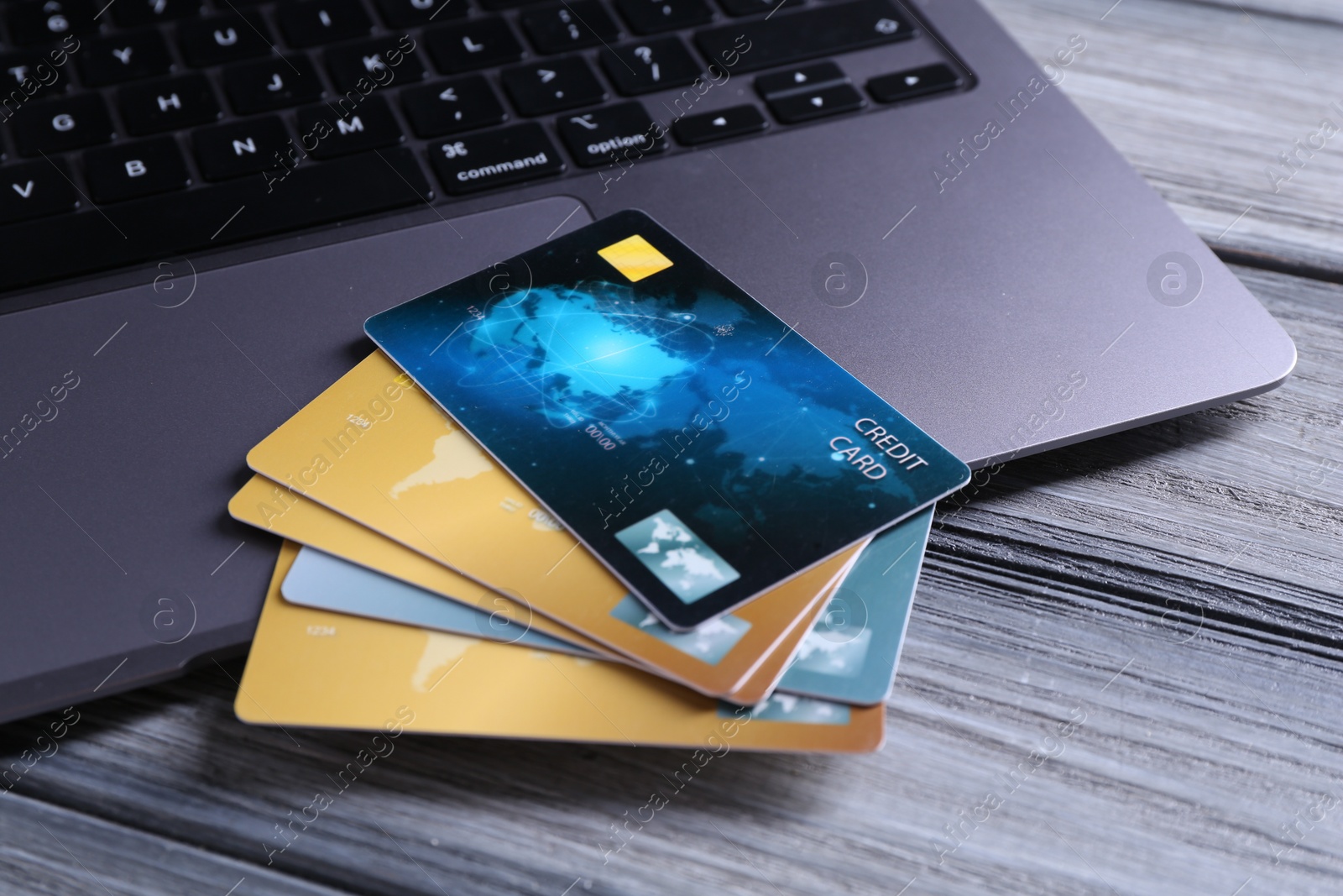 Photo of Credit cards and laptop on grey wooden table