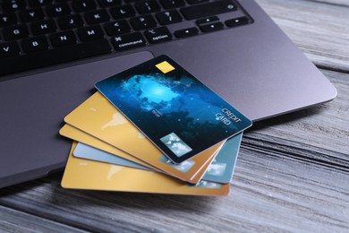 Photo of Credit cards and laptop on grey wooden table