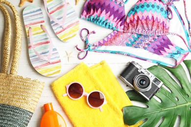 Flat lay composition with beach objects on white wooden background